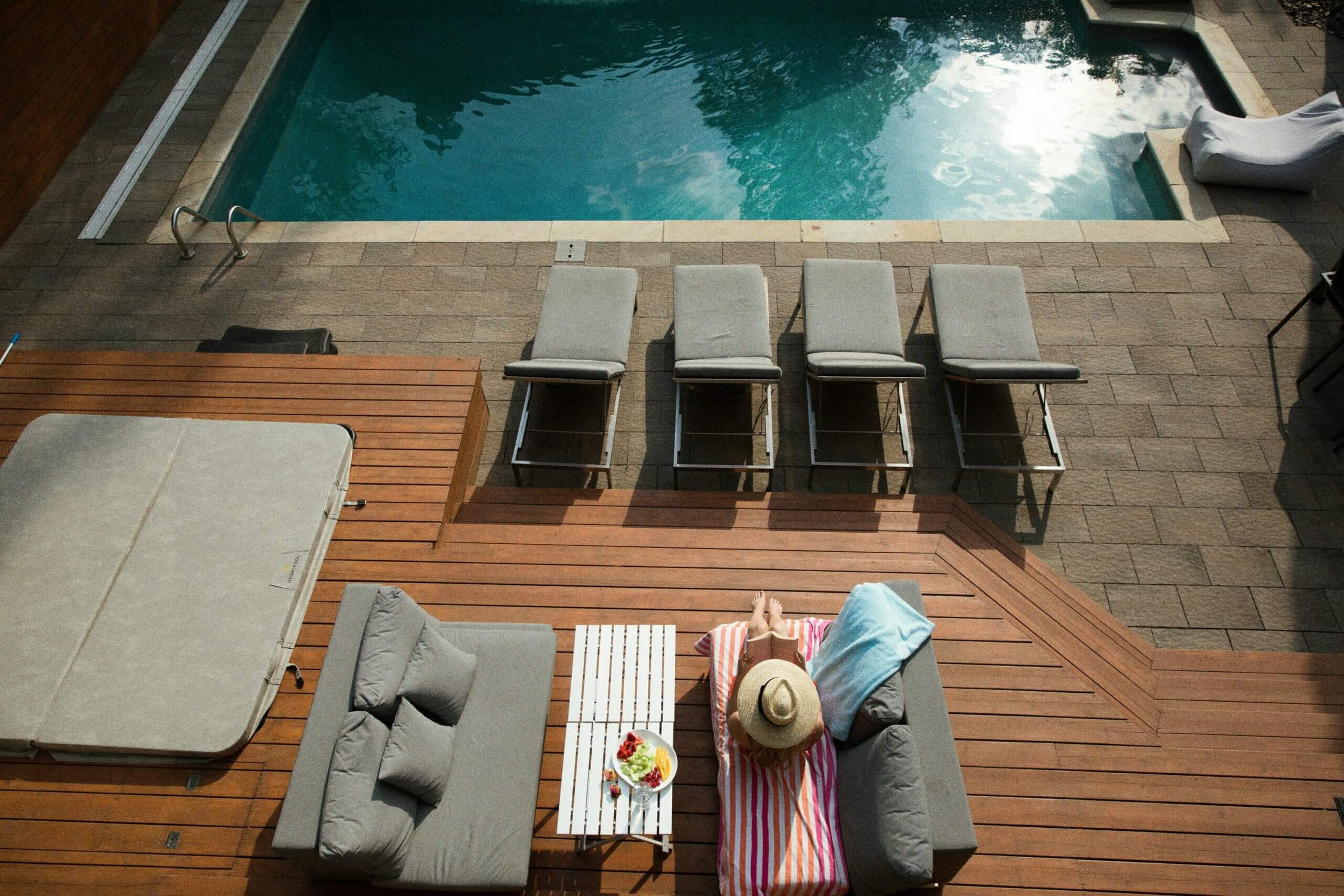 femme sur un transat le long d'une piscine