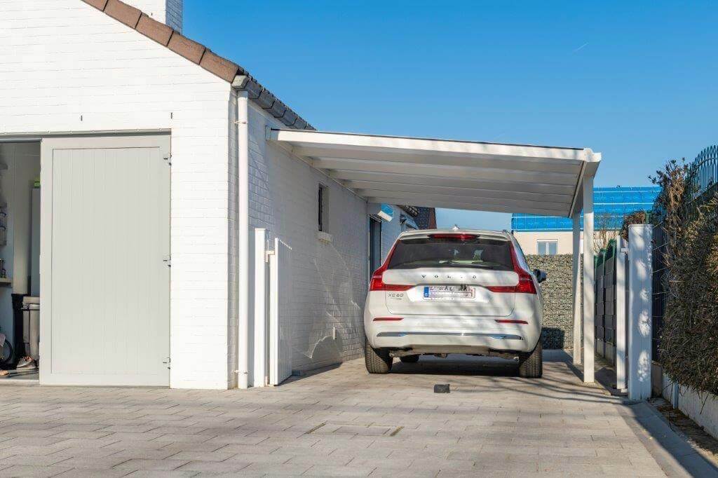 Carport voiture blanc à coté d'une maison